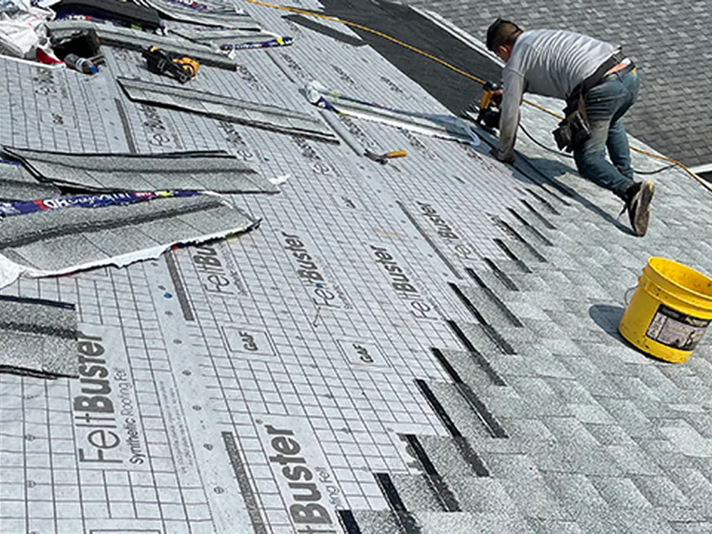 Rhino Roofing installer laying new asphalt shingles over synthetic underlayment