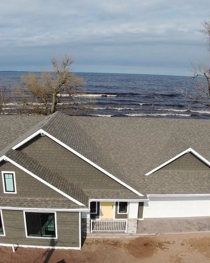 Aerial view of a home with new roof and gutters